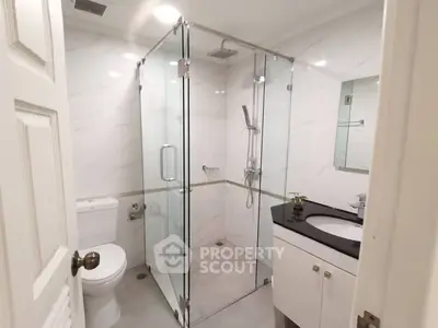 Modern bathroom with glass shower enclosure and sleek vanity