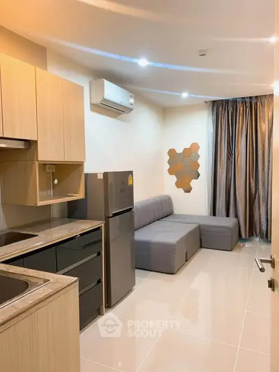 Modern apartment interior with sleek kitchen and cozy living area, featuring stylish decor and ample natural light.