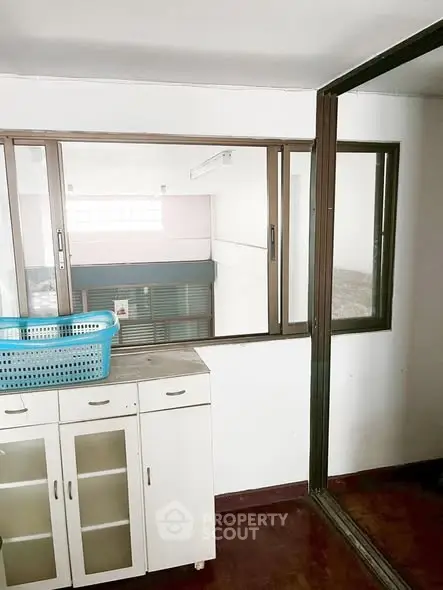 Spacious interior with large windows and storage cabinet, ideal for versatile use.