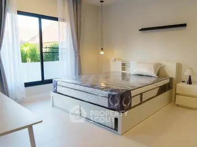 Bright and airy bedroom with large window and modern furnishings