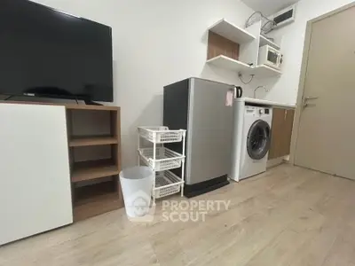 Modern compact kitchen with appliances and storage solutions in a cozy apartment.