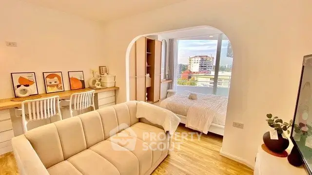 Bright modern living room with cozy sofa and stylish decor, featuring a view of the cityscape.