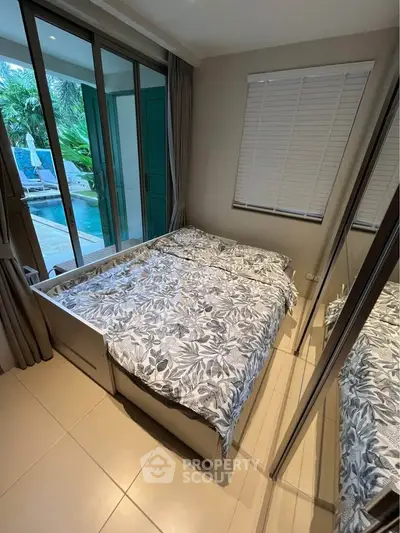 Cozy bedroom with pool view and mirrored closet doors, perfect for relaxation and comfort.