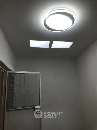 Minimalist room with modern ceiling light and small window