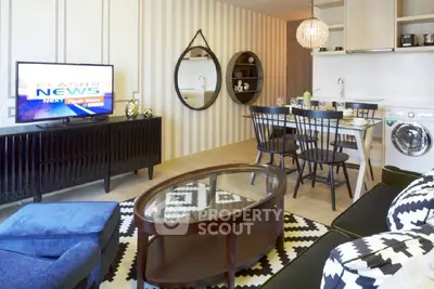 Modern living room with stylish decor, open kitchen, and cozy seating area.
