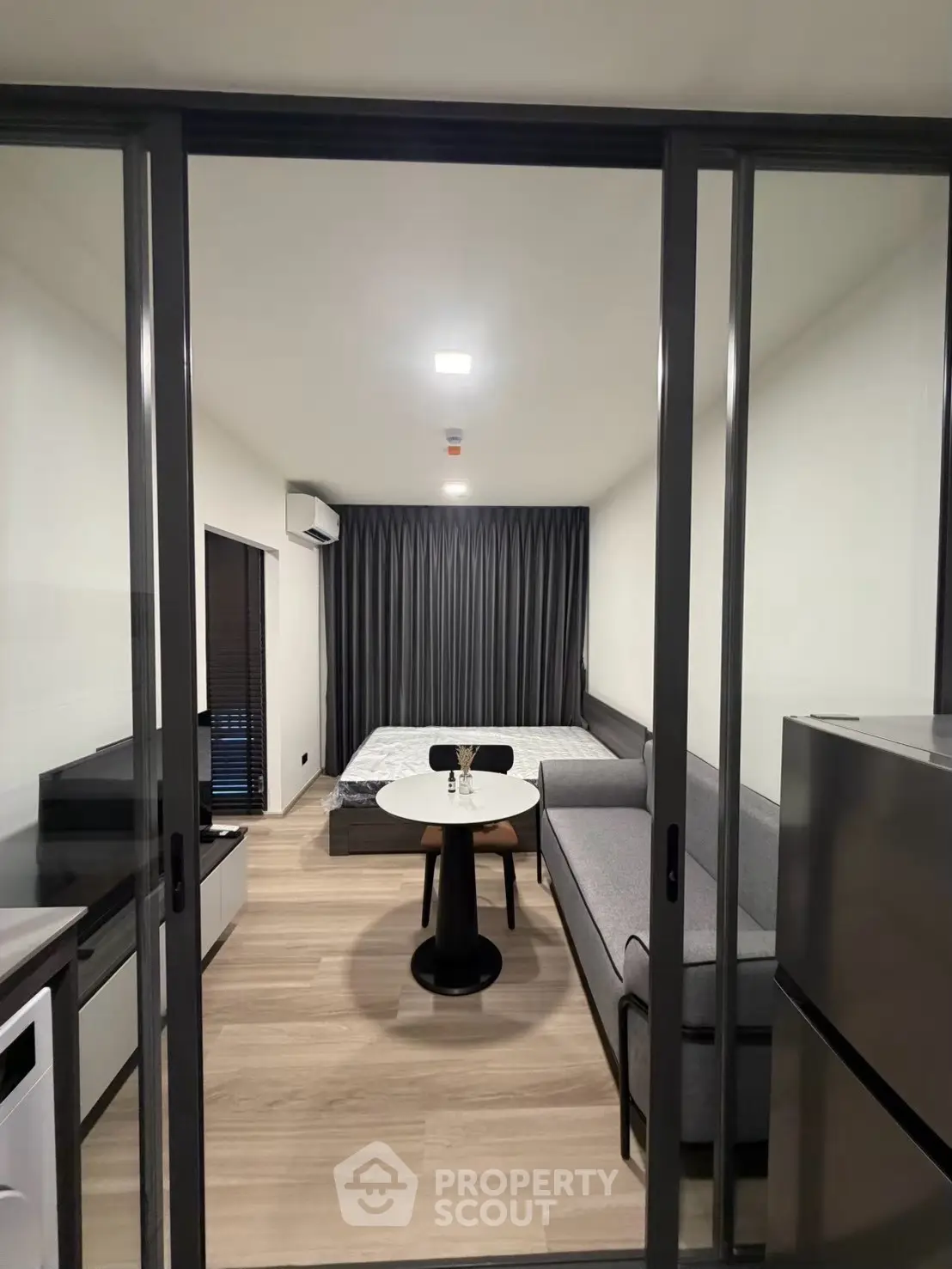 Modern studio apartment with sleek design and cozy furnishings, featuring a compact living area and bedroom.