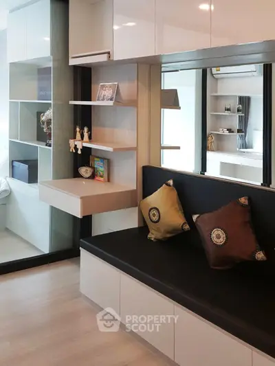 Modern living room with sleek built-in shelves and cozy seating area, perfect for urban living.