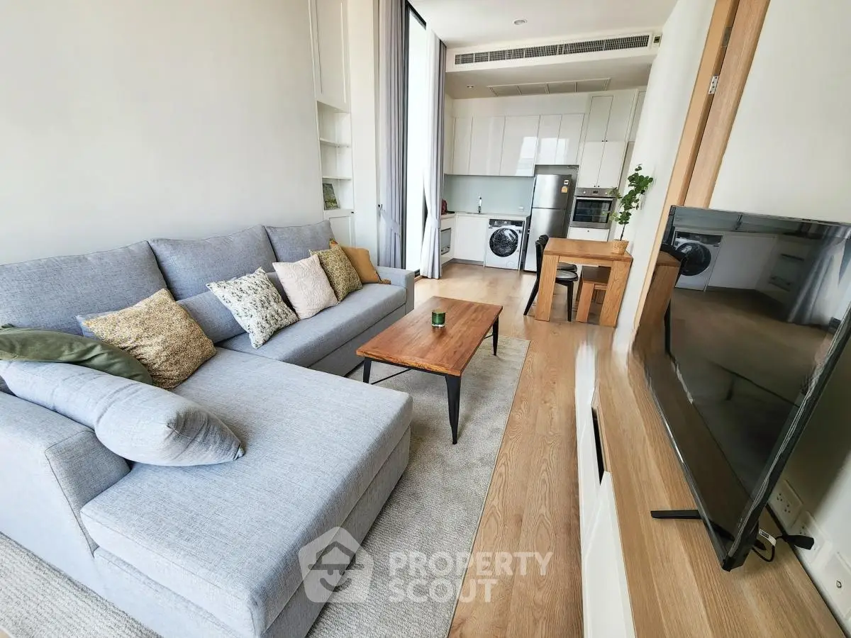 Modern living room with cozy sofa and open kitchen layout