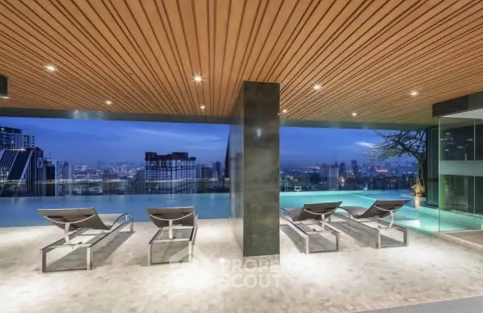 Luxurious rooftop pool with stunning city skyline view, featuring modern lounge chairs and elegant design.