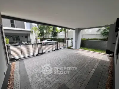 Spacious modern carport with sleek design and gated entrance in a contemporary home.