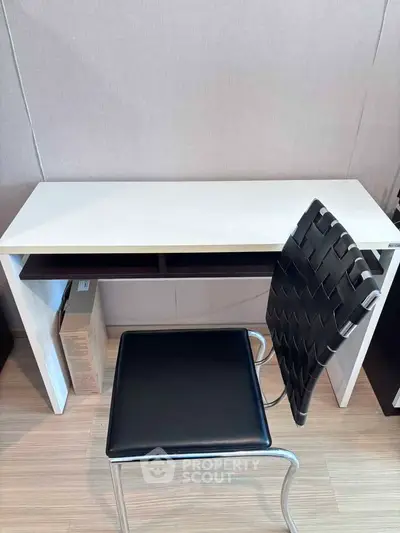 Modern minimalist study area with sleek white desk and stylish black chair, perfect for productivity.