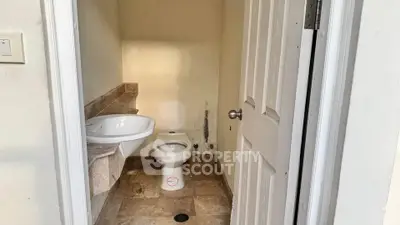 Compact bathroom with basic fixtures and neutral tones