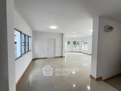 Spacious and bright interior with large windows and glossy tiled flooring