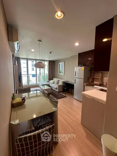 Modern open-layout living room and kitchen with stylish decor and natural light.