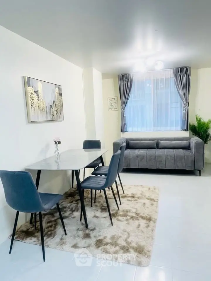 Modern living room with stylish dining set and cozy sofa, perfect for urban living.