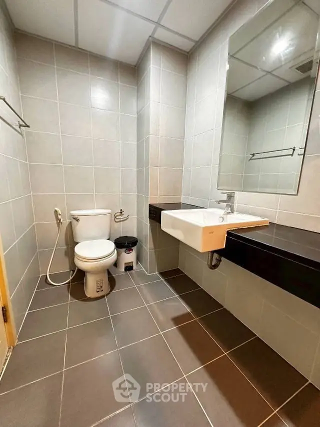 Modern bathroom with sleek fixtures and large mirror in a contemporary apartment.