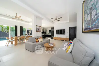 Spacious open-plan living area with modern furniture, seamlessly connecting to an outdoor pool, perfect for entertaining and relaxation.