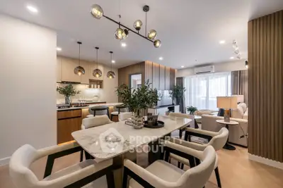 Luxurious open-plan living and dining area with modern lighting and elegant decor.