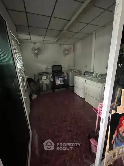 Cozy laundry room with multiple washing machines and dryers, perfect for efficient home living.