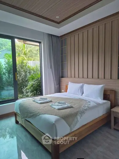 Luxurious bedroom with modern design and garden view, featuring elegant wooden accents and large windows.