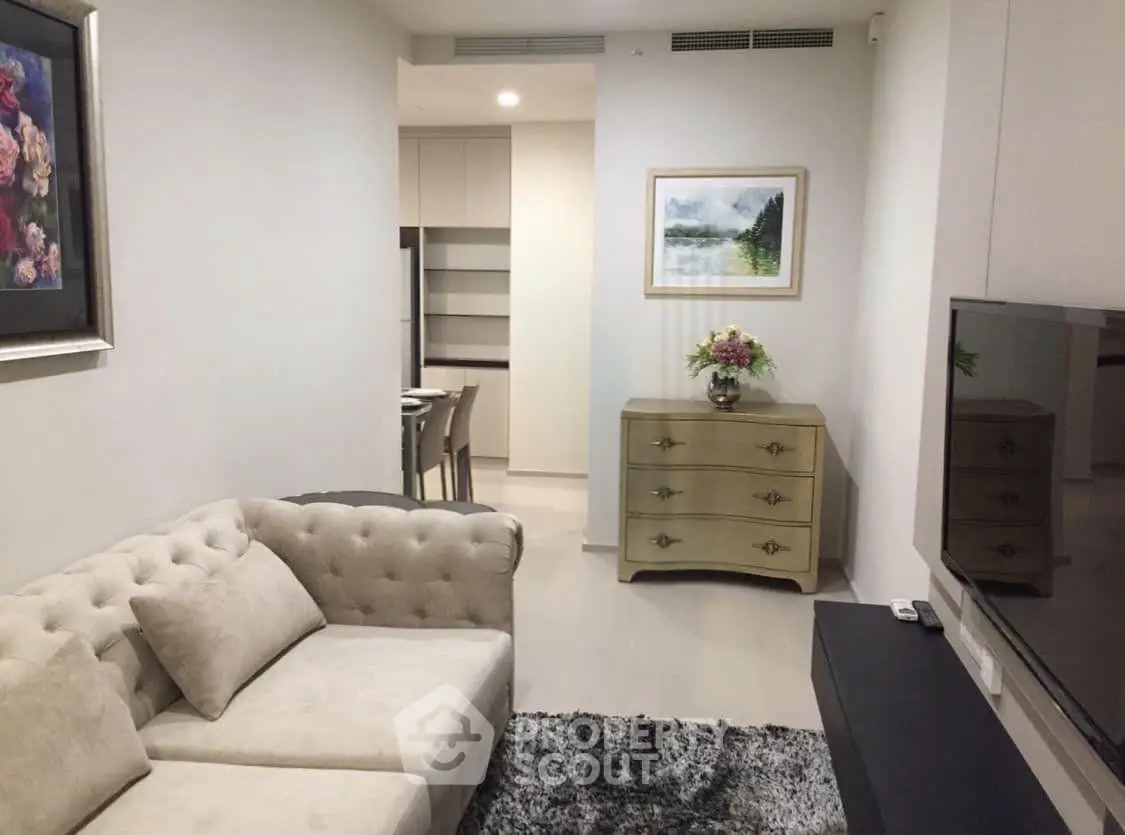Elegant living room with plush sofa, stylish decor, and modern TV setup in a cozy apartment.