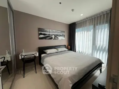 Modern bedroom with stylish decor and large windows offering natural light.