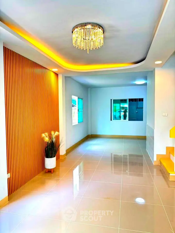 Modern living room with elegant chandelier and stylish wall paneling