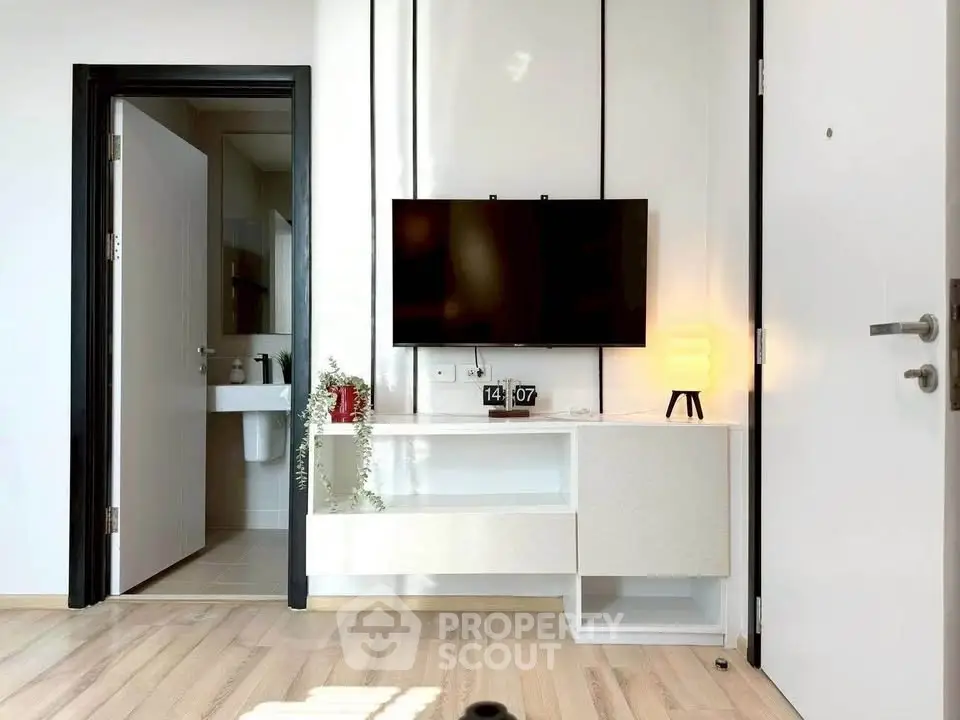 Modern living room with wall-mounted TV and sleek white furniture