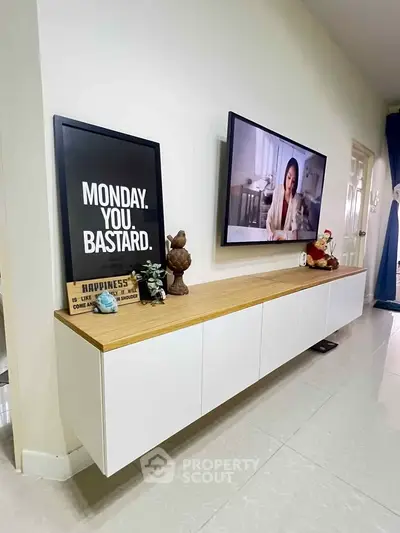 Modern living room with sleek wall-mounted cabinet and large TV, perfect for entertainment.