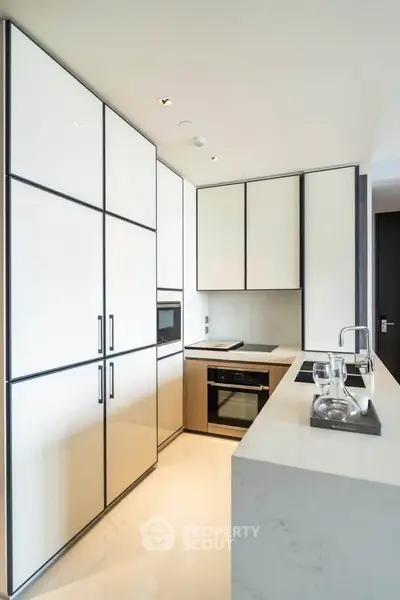 Modern kitchen with sleek cabinetry and built-in appliances in a contemporary apartment.