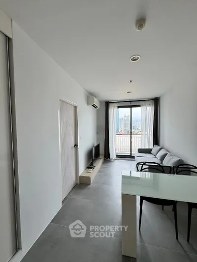 Modern living room with sleek design and city view balcony in high-rise apartment.