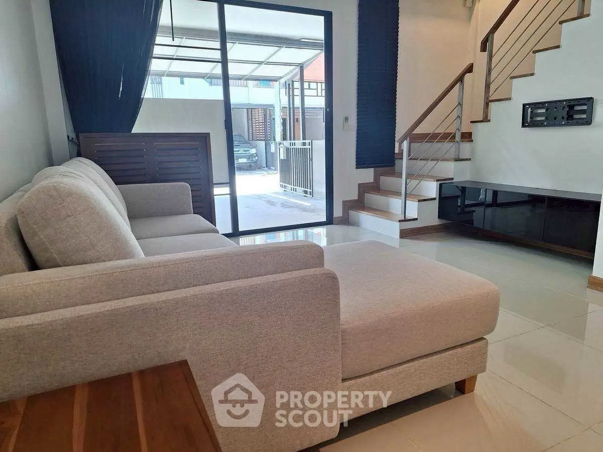 Modern living room with sleek staircase and large window view