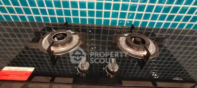 Modern kitchen with sleek gas stove and stylish blue tile backsplash.