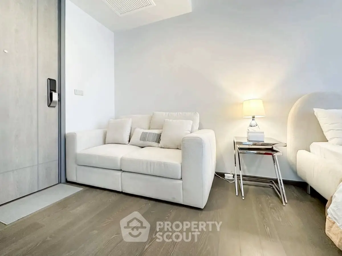 Modern living room with cozy white sofa and stylish lamp on wooden floor