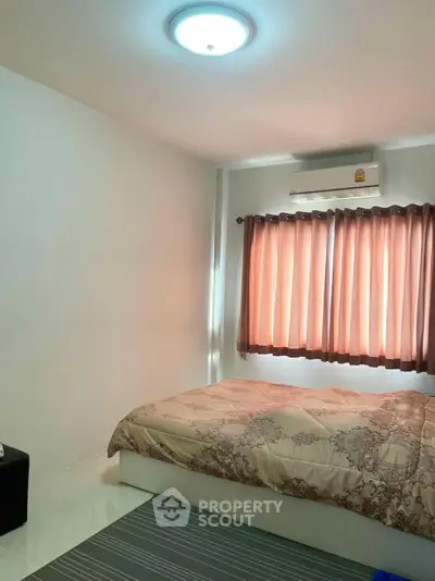 Cozy bedroom with air conditioning and elegant bedding in a well-lit space.