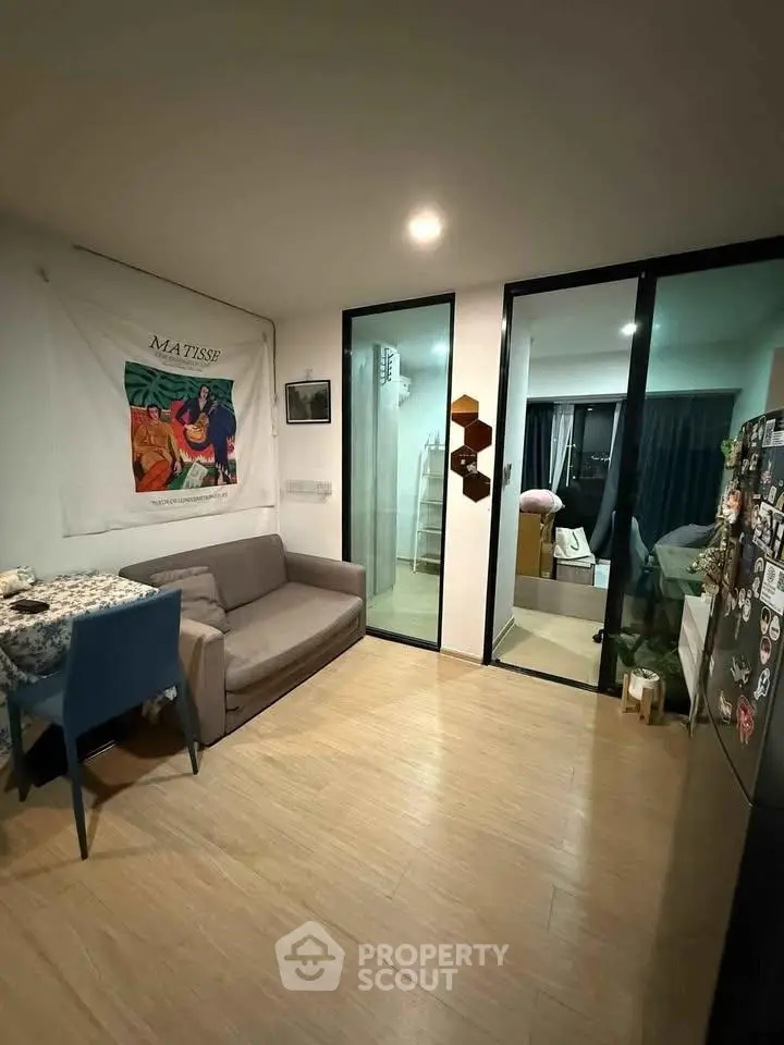 Cozy living room with modern decor and glass partition leading to bedroom