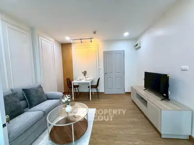 Modern living room with cozy seating and dining area, featuring stylish decor and wooden flooring.