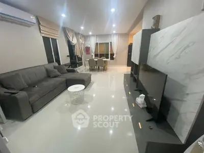 Spacious modern living room with sleek furniture and dining area, perfect for family gatherings.