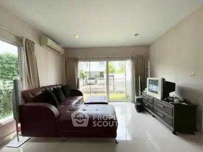 Spacious living room with modern furniture and large windows offering garden view