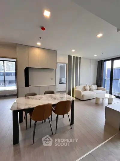 Modern living room with elegant dining area and stylish furniture in a bright open layout.