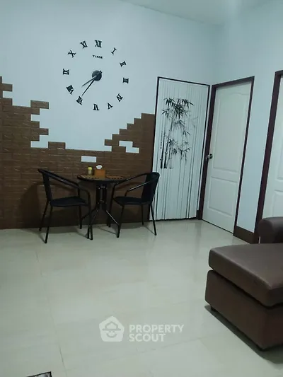Cozy living room with stylish wall clock and comfortable seating area.