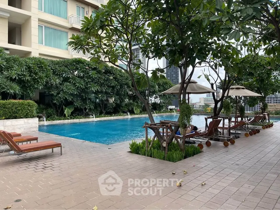 Luxurious apartment complex with a stunning outdoor pool and lush greenery.