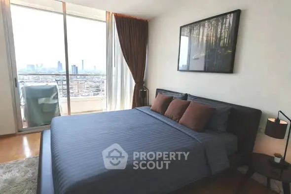 Modern bedroom with city view and balcony access, featuring stylish decor and natural light.