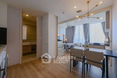 Modern open-plan living room with dining area and stylish lighting in a contemporary apartment.
