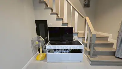 Modern interior with sleek staircase and TV unit, perfect for stylish living.