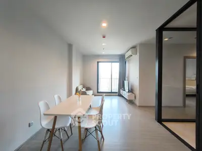 Spacious modern living room with dining area and balcony access in a stylish apartment.