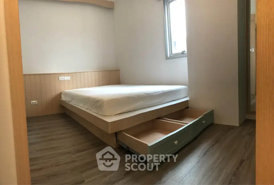 Modern bedroom with wooden flooring and built-in storage under bed