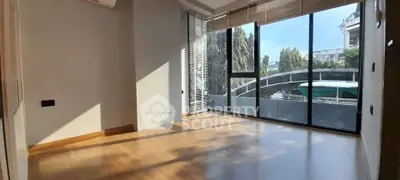 Spacious room with large windows offering abundant natural light and a modern urban view.