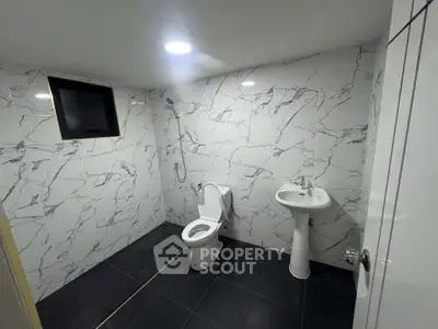 Modern bathroom with marble tiles and sleek fixtures in a contemporary home.