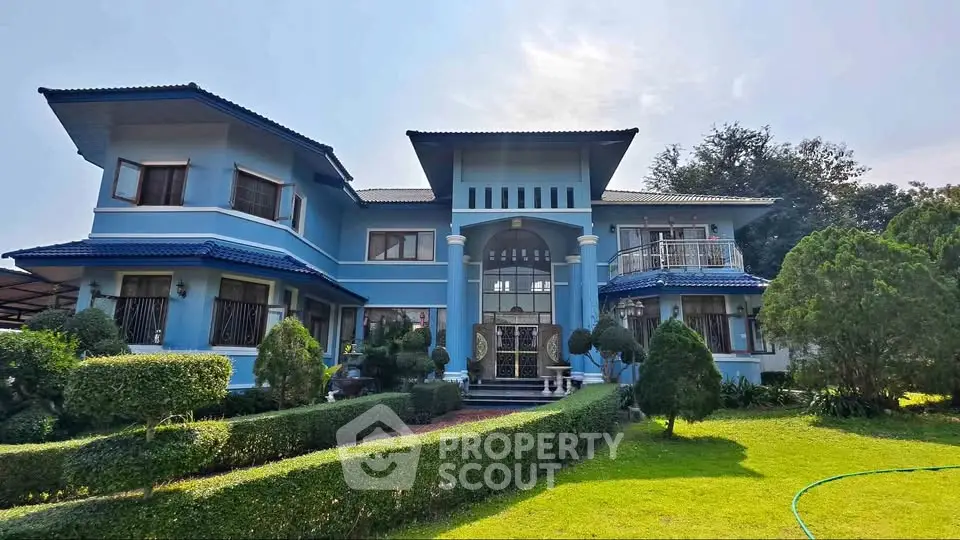 Stunning blue two-story house with lush garden and elegant entrance